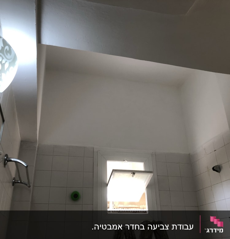 קיר צבוע בלבן עם סולם קטן בחדר אמבטיה